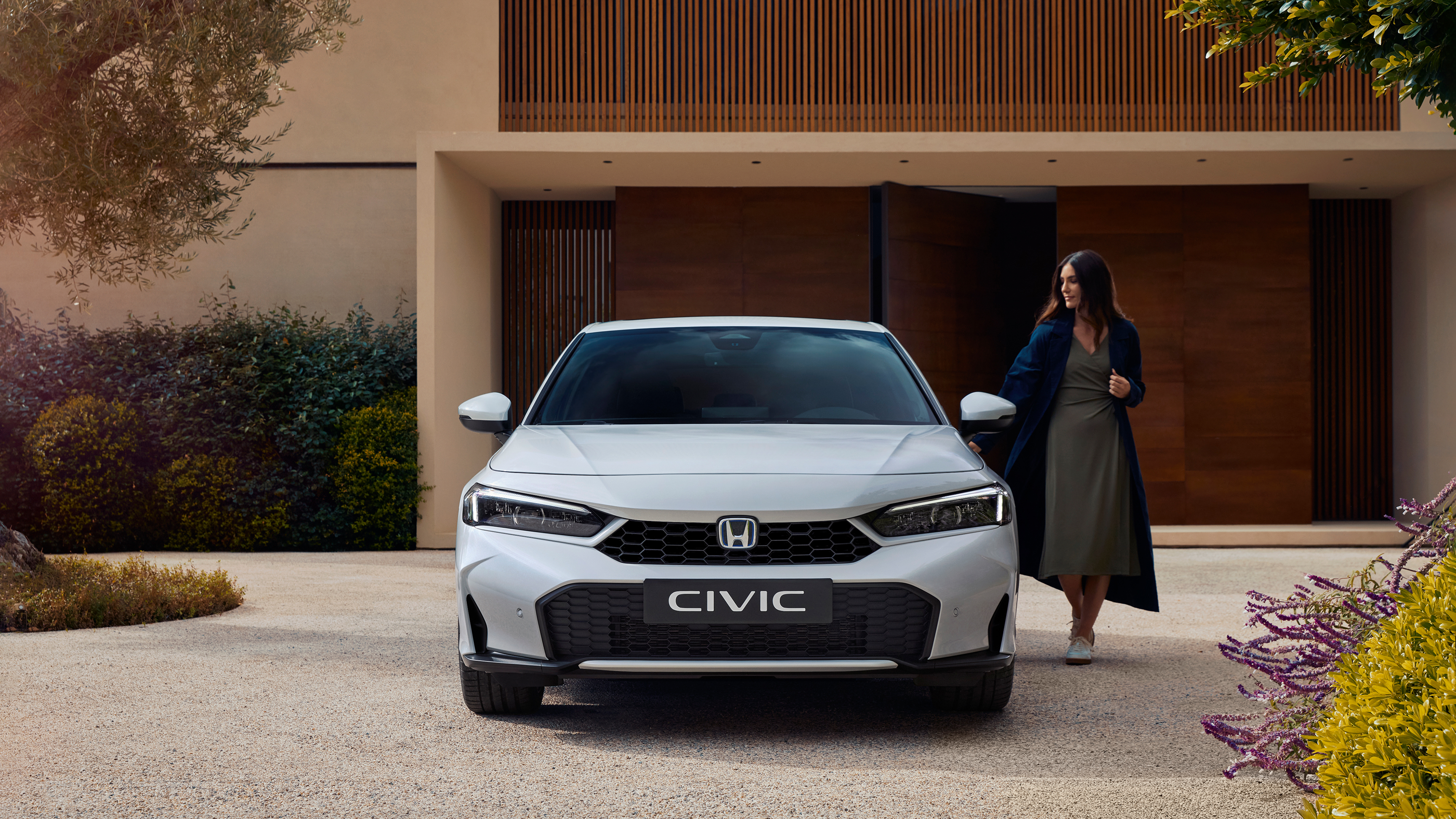 Plan de face d'une Civic Hybrid, avec une femme ouvrant sa porte.